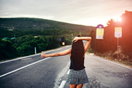 Long hair brunette tourist girl walking on the roadの写真素材