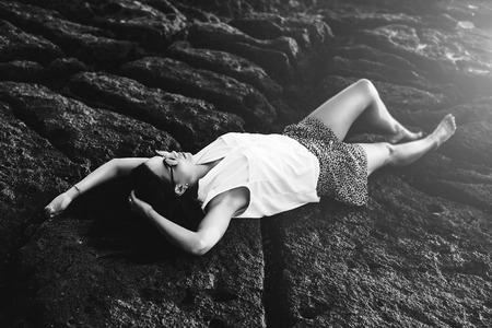 Long hair brunette girl relaxing in the stonesの写真素材
