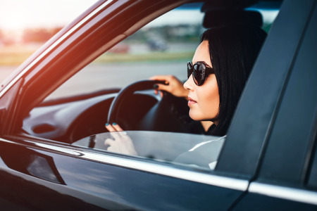 Brunette girl driving car on the roadの写真素材
