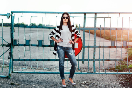 Brunette girl outdoor with old fence behindの写真素材