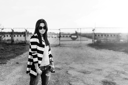 Brunette girl outdoor with old fence behindの写真素材