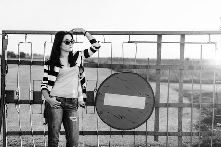 Brunette girl outdoor with old fence behindの写真素材
