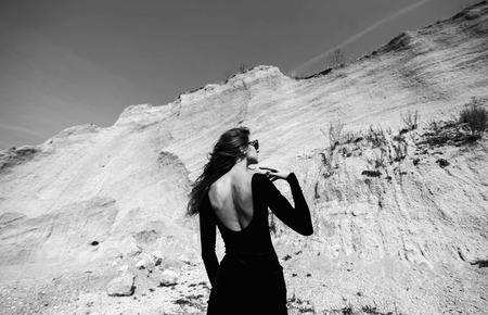 Woman in long black dress walking outdoorの写真素材