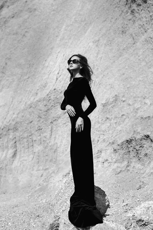 Woman in long black dress walking outdoorの写真素材