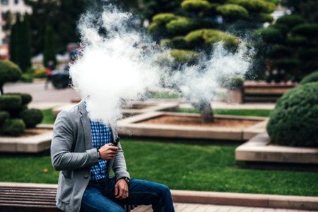 Men with beard smoking electronic cigarette outdoor, focus on steam