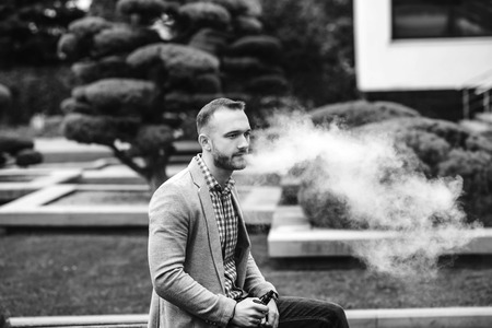 Men with beard vaping electronic cigarette outdoorの写真素材