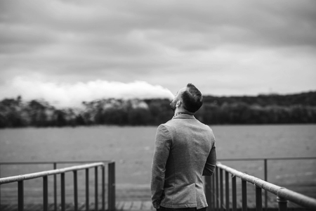 Men with beard vaping electronic cigarette outdoorの写真素材