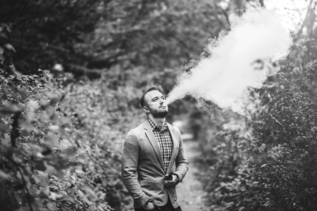 Men with beard vaping electronic cigarette outdoorの写真素材