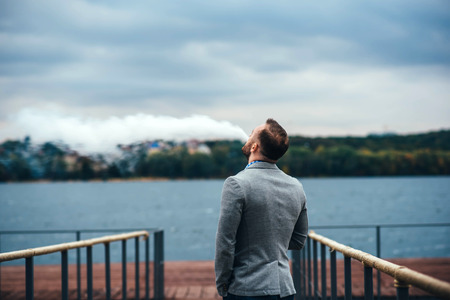 Men with beard vaping electronic cigarette outdoorの写真素材