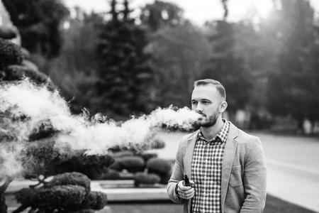 Men with beard vaping electronic cigarette outdoorの写真素材