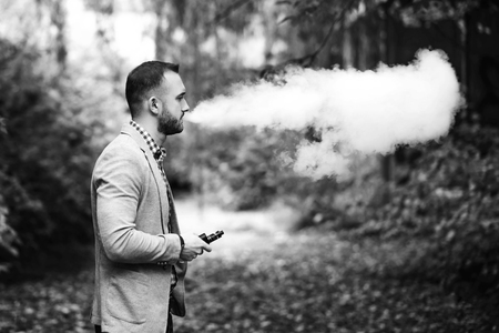 Men with beard vaping electronic cigarette outdoorの写真素材