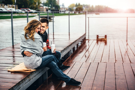 Happy pretty couple drinking hot coffee outdoorの写真素材