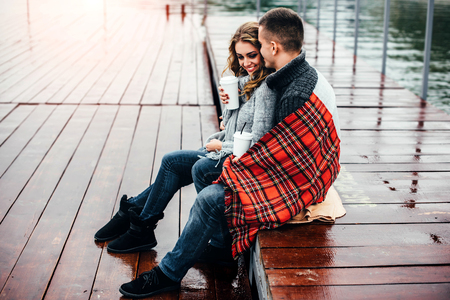 Happy pretty couple drinking hot coffee outdoorの写真素材