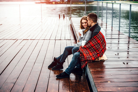 Happy pretty couple drinking hot coffee outdoorの写真素材