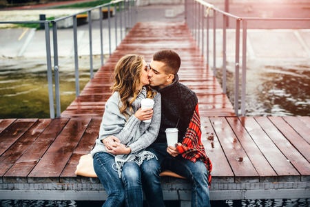 Happy pretty couple drinking hot coffee outdoorの写真素材