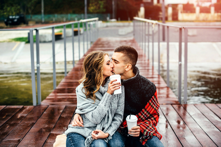 Happy pretty couple drinking hot coffee outdoorの写真素材