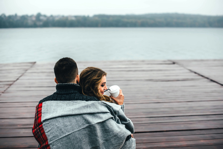 Happy pretty couple drinking hot coffee outdoorの写真素材