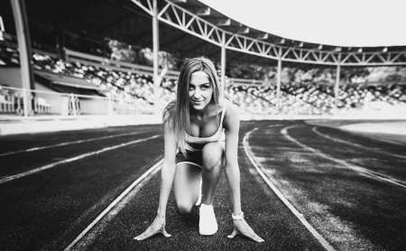 Girl workout on stadium in blue shortsの写真素材