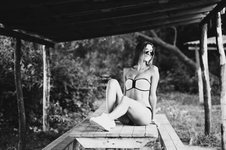 Sporty girl sitting on the wooden table outdoorの写真素材