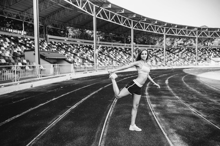 Girl workout on stadium in blue shortsの写真素材