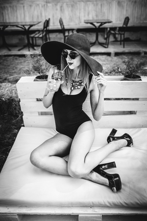 Young pretty sexy girl drinking cold beverage outdoor in beach cafeの写真素材