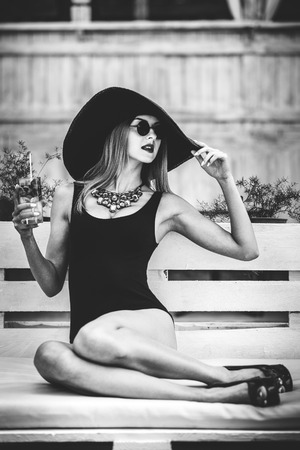 Young pretty sexy girl drinking cold beverage outdoor in beach cafeの写真素材