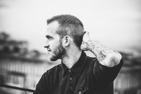 Man with beard on the top of the high building with cityscape on backgroundの写真素材