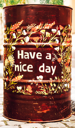 Friendly metal barrel on the street outdoor with "have a nice day" printの写真素材