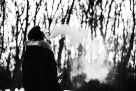 Man with beard smoke electronic cigarette outdoorの写真素材