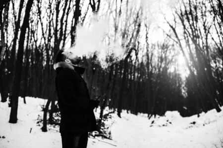 Man with beard smoke electronic cigarette outdoorの写真素材