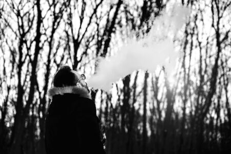 Man with beard smoke electronic cigarette outdoorの写真素材
