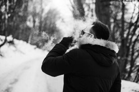 Man with beard smoke electronic cigarette outdoorの写真素材