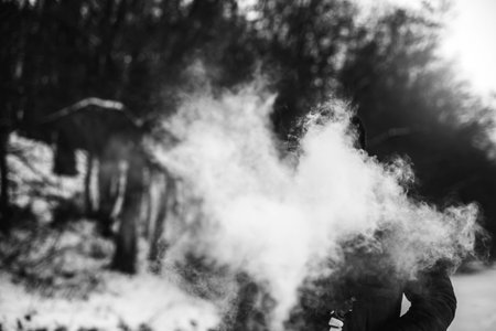 Man with beard smoke electronic cigarette outdoorの写真素材