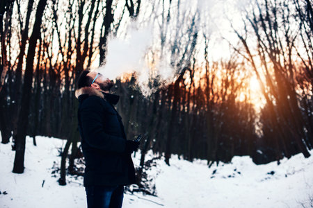 Man with beard smoke electronic cigarette outdoorの写真素材