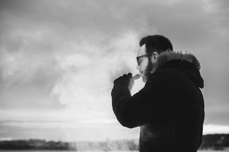 Man with beard vape electronic cigarette outdoorの写真素材