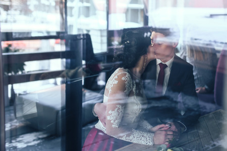 Happy wedding couple relaxing in cafeの写真素材