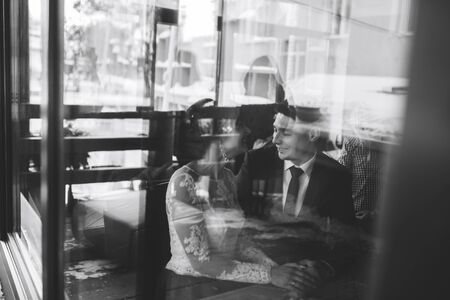 Happy wedding couple relaxing in cafeの写真素材