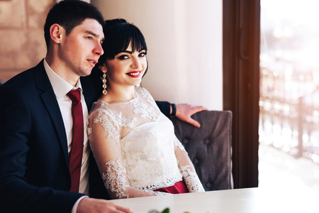 Happy wedding couple relaxing in cafeの写真素材