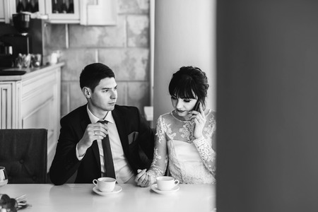 Happy wedding couple relaxing together in cafeの写真素材