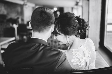 Happy wedding couple relaxing together in cafeの写真素材