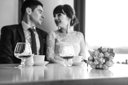 Happy wedding couple relaxibg together in cafeの写真素材