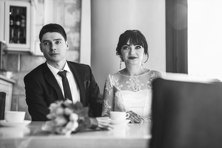 Happy wedding couple relaxing together in cafeの写真素材