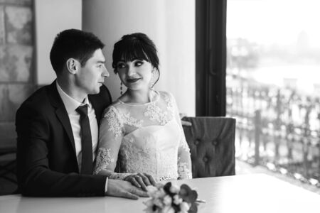 Happy wedding couple relaxing in cafeの写真素材