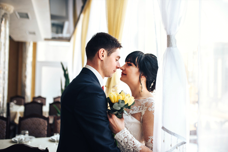 Happy wedding couple relaxing in restaurantの写真素材