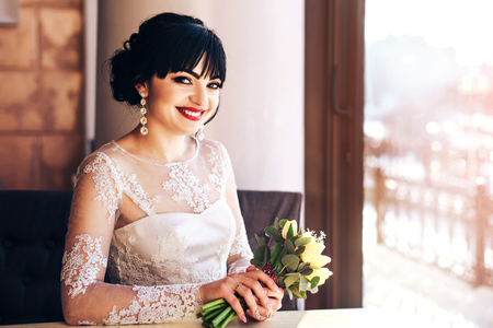 Pretty happy bride sitting in the cafeの写真素材