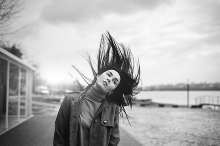 Young brunette woman outdoor with blowing up hairの写真素材