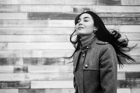 Young brunette woman outdoor with blowing up hairの写真素材