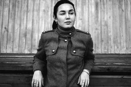 Young brunette girl sitting outdoor on the benchの写真素材