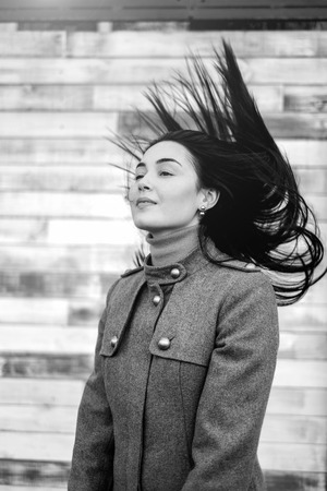 Young brunette woman outdoor with blowing up hairの写真素材