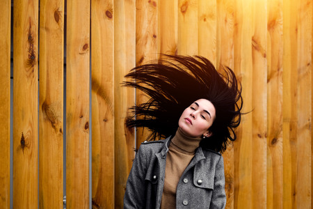 Young brunette woman outdoor with blowing up hairの写真素材